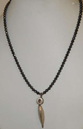 Necklace with hematite beads and gold colored pendant