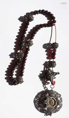 Rosary with dark red cut beads and filigree worked ball elem...