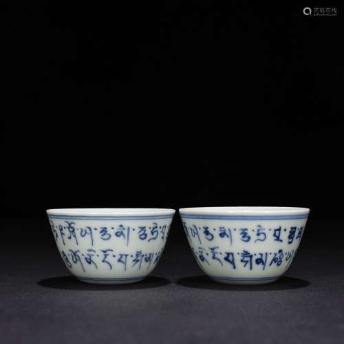 pair of blue and white Sanskrit cups