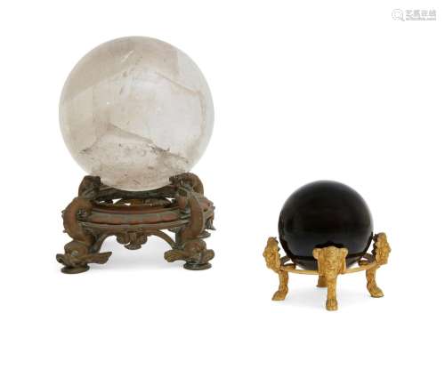 A rock crystal sphere & stone sphere on stands