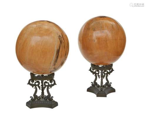 Two hardwood spheres on patinated bronze stands