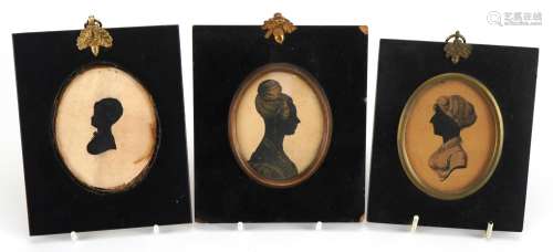 Three hand painted oval silhouettes including two of females...