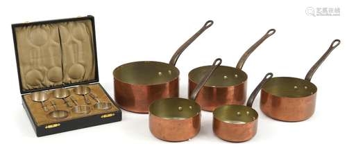 Graduated set of five 19th century copper and iron saucepans...