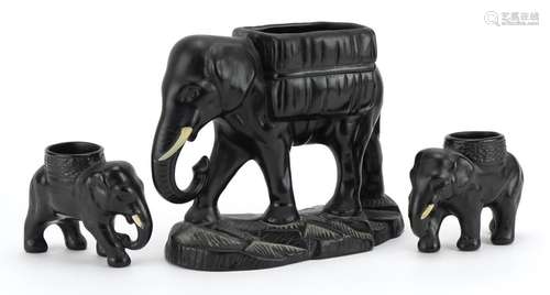 Three early 20th century black painted pottery lion design p...