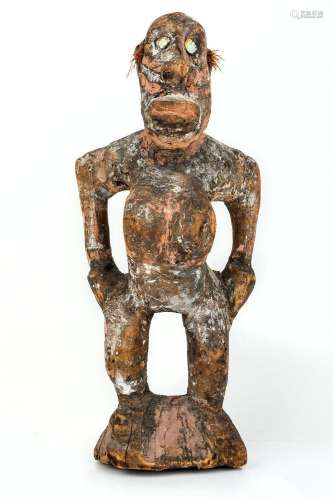 A tribal figure of a woman, stood with bent knees and hands ...