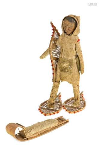 An Inuit carved wood figure, early 20th century, with carved...