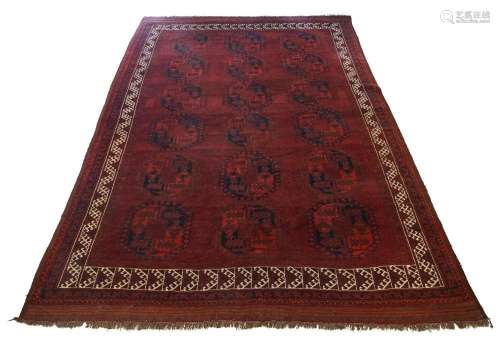 An Afghan bokhara carpet, c.1910, the rich aubergine ground ...