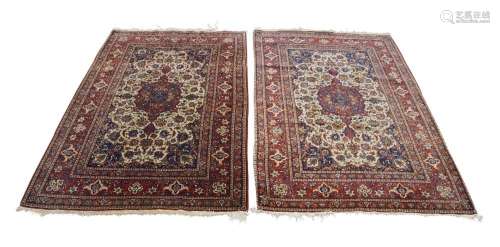 A pair of Persian Isfahan rugs, 20th century, central floral...