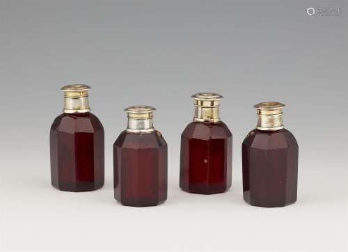 Four vermeil-mounted ruby glass bottles from a travel necess...