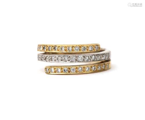 An 18 karat gold bi-colour cross over ring with diamonds. De...