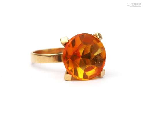 A 14 karat gold orange stone solitaire ring. Featuring an or...