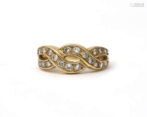 An 18 karat gold infinity ring with diamonds. Featuring twen...