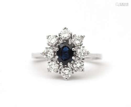 An 18 karat white gold sapphire and diamond cluster ring. Fe...