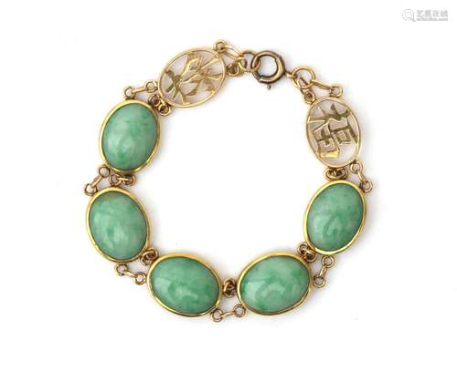 A green jadeite and 14 karat gold link bracelet. Featuring a...