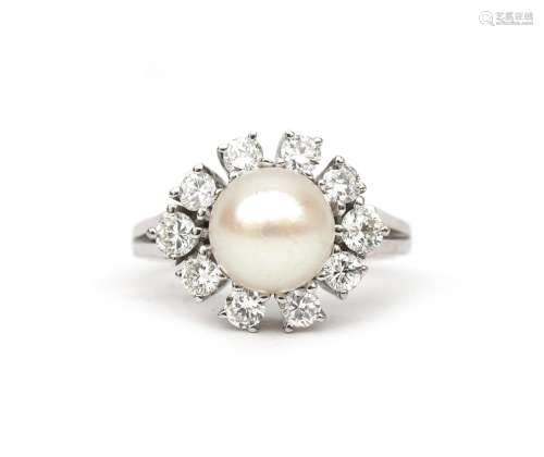 A 14 carat white gold diamond and pearl cluster ring. Featur...