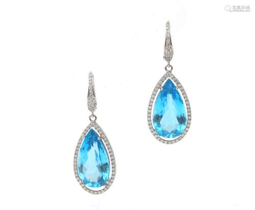 A pair of long earrings with diamonds and topaz. Set with a ...