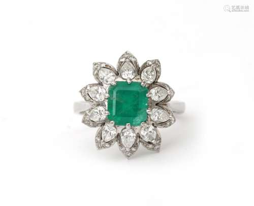 A diamond and emerald cocktail ring. A cluster design featur...