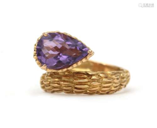 An 18 karat gold amethyst `cross over` ring. Elaborated with...