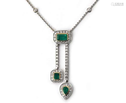 A 14 karat white gold diamond and emerald necklace. A white ...