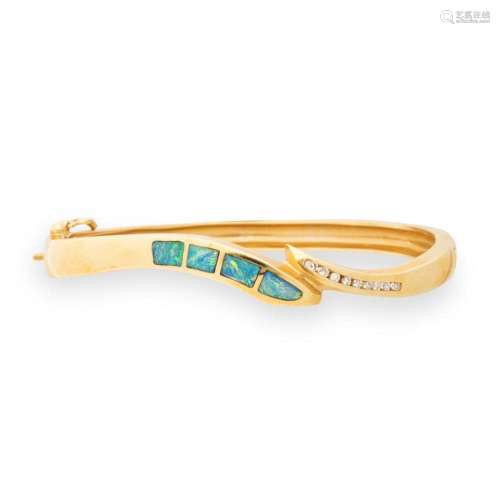A gemstone and fourteen karat gold bangle bracelet