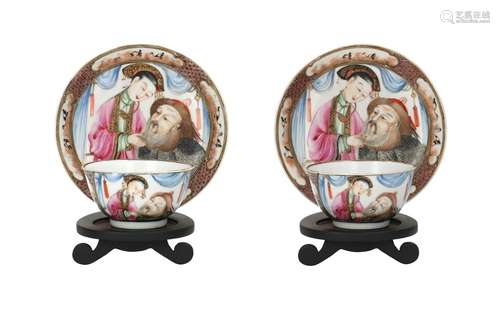 A pair of polychrome porcelain cups with saucers on wooden s...