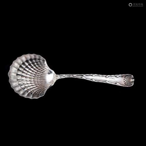 A Tiffany Wave Edge sterling berry spoon with a shell shaped...