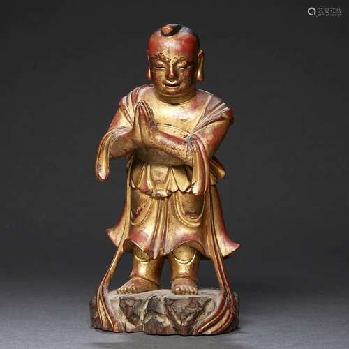 STATUETTE<br />
en bois laqué rouge et or, représentant un a...