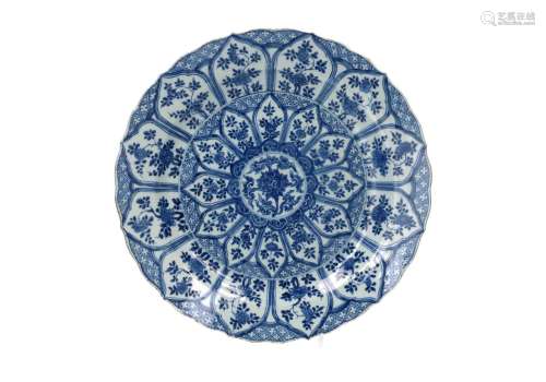 A blue and white porcelain charger with scalloped rim