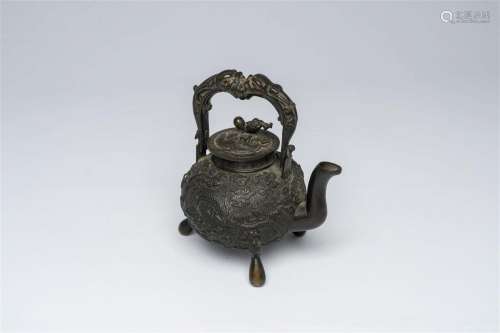 A Chinese tripod bronze teapot and cover with dragon relief ...