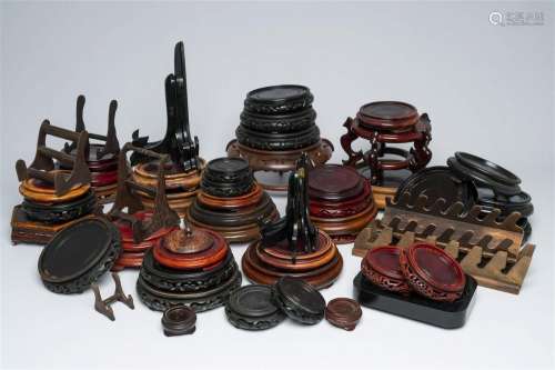 A varied collection of Chinese carved wood stands and plate ...