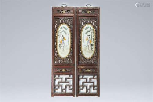A pair of Chinese open worked carved wood panels with famill...