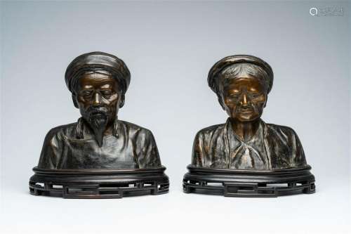 A pair of Vietnamese patinated bronze busts of elders on a w...