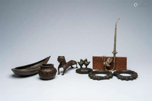 A varied collection of metal objects and a carved wood panel...