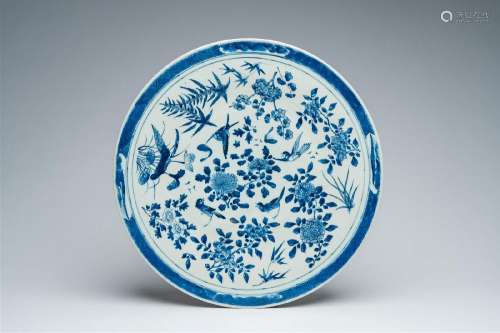 A large Chinese blue and white charger with birds among blos...
