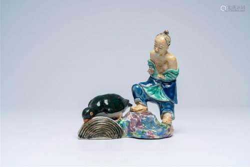 A Chinese polychrome group depicting an elder and a piscivor...