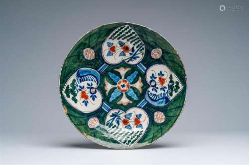 A Dutch Delft green-ground polychrome 'four-hearts' charger,...