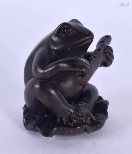 A JAPANESE CARVED BOXWOOD TOAD AND FLUTE NETSUKE. 4 cm x 2.5...