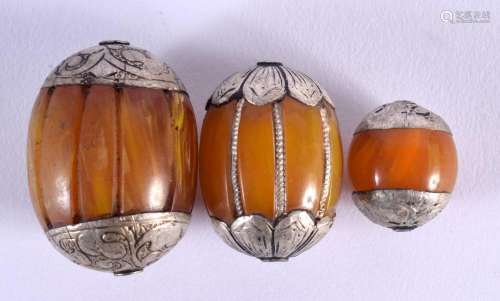 THREE EARLY 20TH CENTURY MIDDLE EASTERN SILVER AND AMBER TOG...