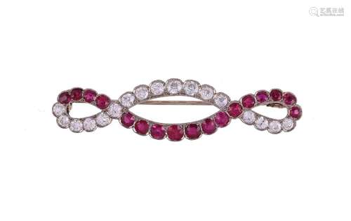 AN EARLY 20TH CENTURY DIAMOND AND RUBY CROSSOVER BROOCH