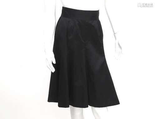 A black Chanel skirt with gold colored CC buttons at the bac...
