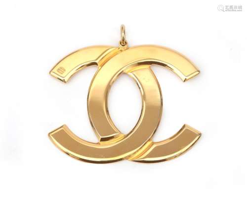 A Chanel CC logo pendant. A gold tone pendant with the two C...