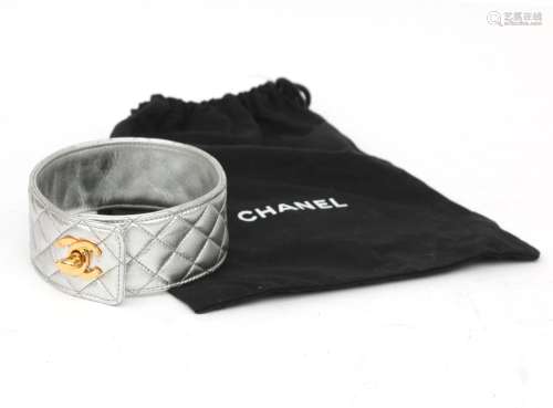 A silver coloured leather Chanel collar. With gold tone turn...