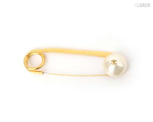 A gilded Chanel safety pin brooch. Featuring a bouton of fau...