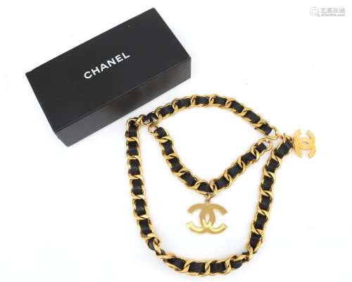 A gold tone and black leather Chanel chain belt. A gilded an...