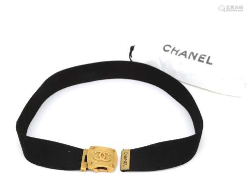 A black Chanel canvas belt with bronze buckle. With white Ch...