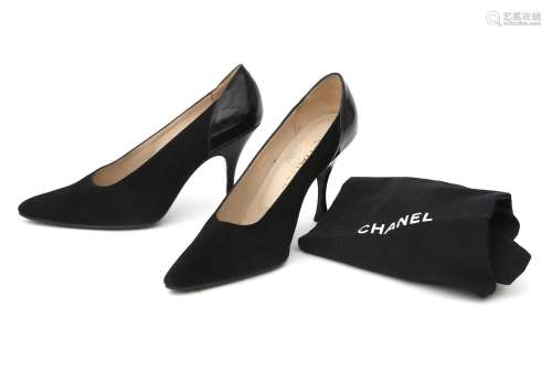 A pair of black leather Chanel pumps with stiletto heels. he...