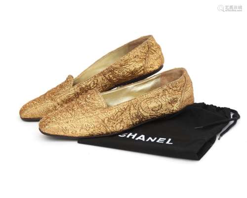 A pair of gold Chanel loafers, size 37.5 (US 7). Pattern of ...