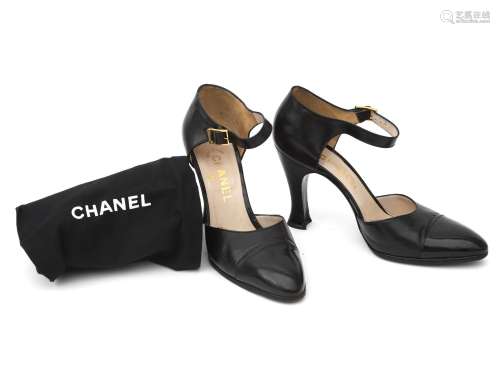 A pair of black leather Chanel pumps with anklet. Slight poi...