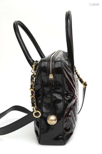 A black leather Chanel chevron schoulder bag. Made of patent...