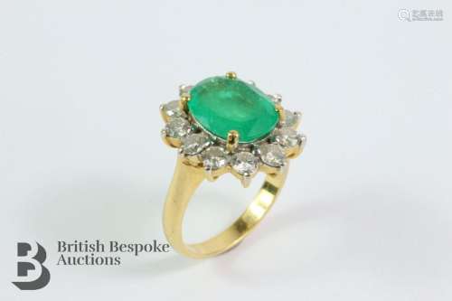 18ct gold emerald and diamond ring. The ring set with an ova...